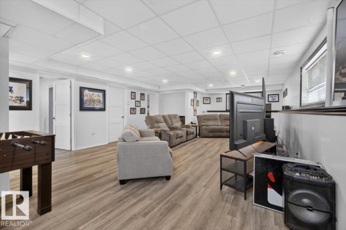 Spacious finished room featuring wood-finish flooring, recessed lighting, and multiple windows - 3907 33 Street, Edmonton, AB 
