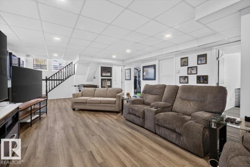 Spacious finished room featuring wood-finish flooring, recessed lighting, and a drop ceiling - 3907 33 Street, Edmonton, AB 
