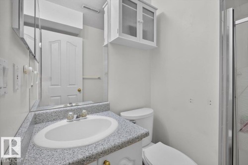 White vanity with a granite-finish countertop and integrated oval sink - 3907 33 Street, Edmonton, AB 