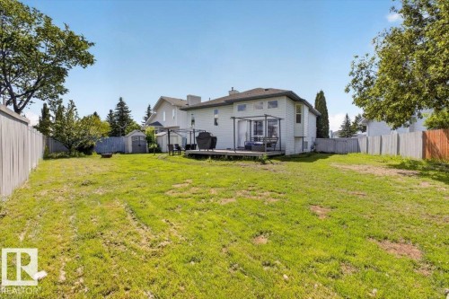 Expansive backyard featuring a large green space, privacy fencing, a wood deck, and an outdoor storage shed - 3907 33 Street, Edmonton, AB 