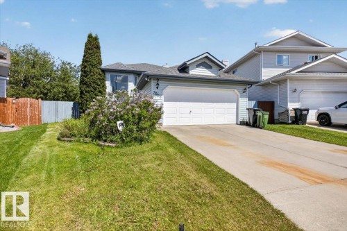 Property exterior featuring light blue siding, an attached two-car garage, and a concrete driveway - 3907 33 Street, Edmonton, AB 