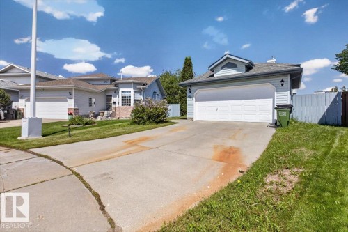 Detached residence featuring a light blue siding exterior and a two-car garage with a white door - 3907 33 Street, Edmonton, AB 