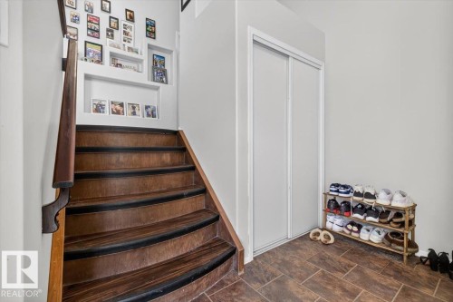 Wood-finish staircase with dark treads and a matching handrail - 3907 33 Street, Edmonton, AB 