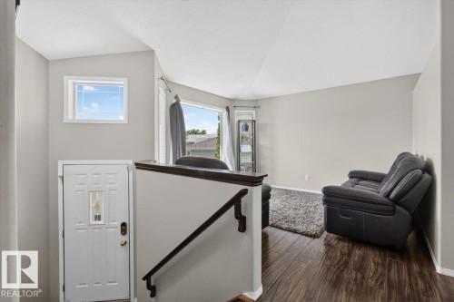 Foyer entry featuring a white panel door with decorative glass insert and an overhead transom window - 3907 33 Street, Edmonton, AB 