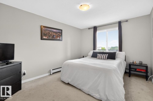 Carpeted room featuring light gray walls, a window with dark curtain rods, and a flush mount ceiling light - 320 5005 165 Avenue, Edmonton, AB - Indoor Photo Showing Bedroom