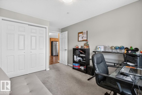 Carpeted room featuring a double bifold closet, light gray wall paint, and a standard ceiling light fixture - 320 5005 165 Avenue, Edmonton, AB - Indoor Photo Showing Office