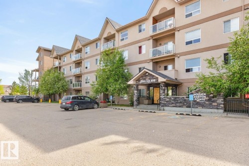 Multi-story residential building featuring a stucco exterior with stone accents and gabled rooflines - 320 5005 165 Avenue, Edmonton, AB - Outdoor With Balcony With Facade