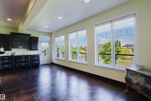 Room featuring dark tile flooring, a wall of windows, and recessed lighting - 3438 West Landing Landing, Edmonton, AB 