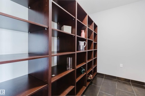 Extensive built-in shelving with a dark wood-finish, providing abundant storage - 3438 West Landing Landing, Edmonton, AB 