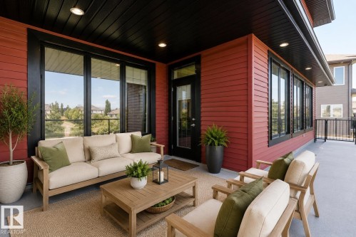 Spacious outdoor patio featuring red horizontal siding, a black slatted ceiling with recessed lighting, and large black-framed windows - 3438 West Landing Landing, Edmonton, AB 