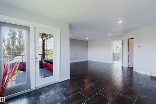 Spacious room with dark tile flooring, white walls, recessed lighting, and white trim - 3438 West Landing Landing, Edmonton, AB 