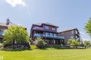 Multi-story residential property featuring a red exterior with multiple balconies - 3438 West Landing Landing, Edmonton, AB 