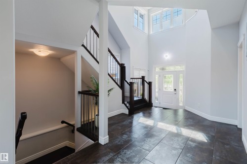 Bright entryway featuring a white paneled door with sidelights, transom windows, and dark tile flooring - 3438 West Landing Landing, Edmonton, AB 