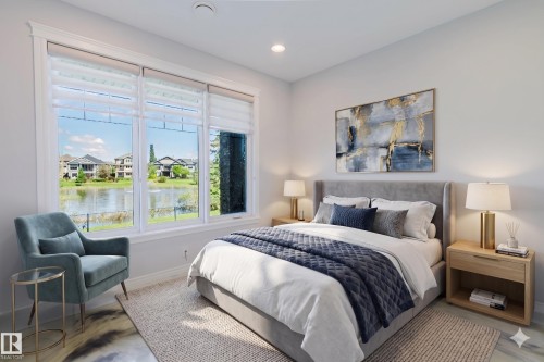 Expansive windows frame a tranquil water feature and surrounding properties - 3438 West Landing Landing, Edmonton, AB 
