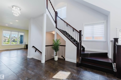 Staircase with dark wood-finish treads and balusters, featuring metal spindles - 3438 West Landing Landing, Edmonton, AB 