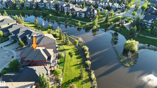 Waterside property with multi-level exterior, featuring a private deck, pitched roofline, and surrounding green space - 3438 West Landing Landing, Edmonton, AB 