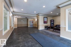 Entryway featuring dark large-format floor tiles, recessed lighting, and crown molding accents - 