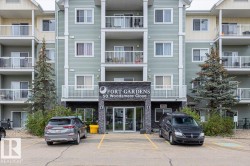 Multi-story residential building featuring light green horizontal siding and white trim - 