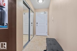 Entryway featuring light-toned tile flooring, recessed ceiling lighting, and a white two-panel door - 