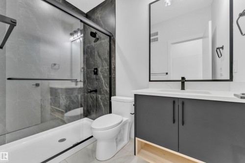 Bathroom featuring a dark gray vanity with a white countertop and a matte black faucet - 4409 35 Street, Beaumont, AB - Indoor Photo Showing Bathroom