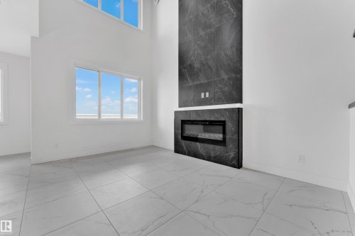 Two-story living area featuring a dramatic fireplace with a full-height dark stone surround - 4409 35 Street, Beaumont, AB - Indoor With Fireplace
