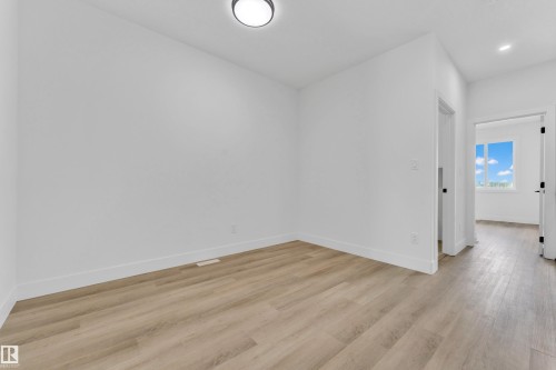 Interior room featuring light wood-finish flooring, white walls, and a contemporary flush-mount ceiling light - 4409 35 Street, Beaumont, AB - Indoor Photo Showing Other Room