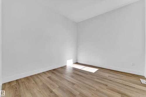 Room featuring light wood-finish flooring, white walls, white baseboards, and a ceiling-mounted light fixture - 4409 35 Street, Beaumont, AB - Indoor Photo Showing Other Room