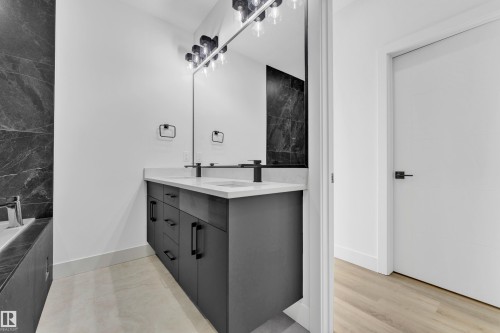 Double vanity featuring a light-toned countertop, dual rectangular sinks, and matte black faucets - 4409 35 Street, Beaumont, AB - Indoor