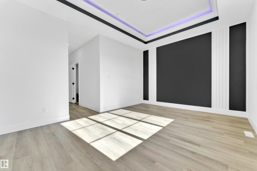 Contemporary interior featuring light wood-finish flooring, white walls, and a tray ceiling with recessed lighting - 4409 35 Street, Beaumont, AB - Indoor Photo Showing Other Room