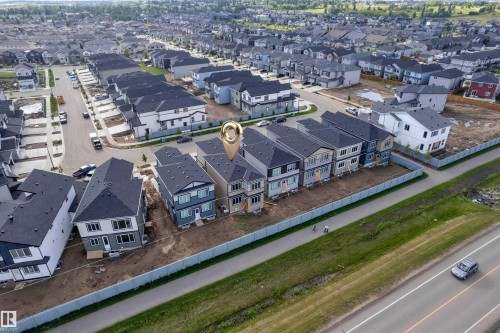 Newly constructed residential community featuring a paved street, uniform fencing, and a variety of contemporary home designs with dark shingle roofs - 4409 35 Street, Beaumont, AB - Outdoor With View