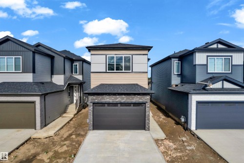 Contemporary two-story residence featuring a two-tone facade, attached garage, and prominent front windows - 4409 35 Street, Beaumont, AB - Outdoor With Facade