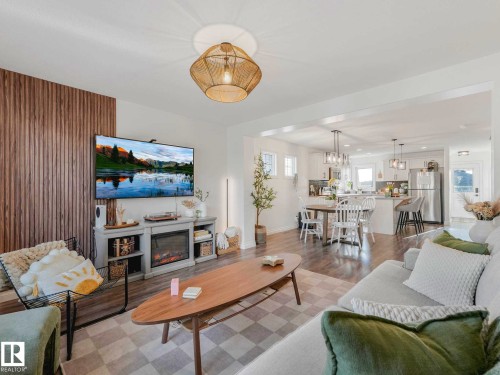 Open-concept living space featuring and a wood slat accent wall - 162 Kirpatrick Way, Leduc, AB 