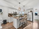 Modern kitchen featuring white cabinetry, stainless steel appliances, a center island with seating, - 162 Kirpatrick Way, Leduc, AB 
