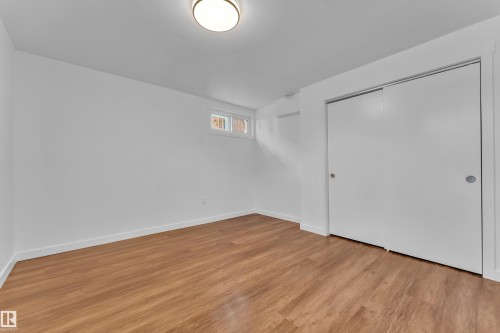 Room featuring wood-finish flooring, white walls, and a recessed window - 8104 135 Avenue, Edmonton, AB 