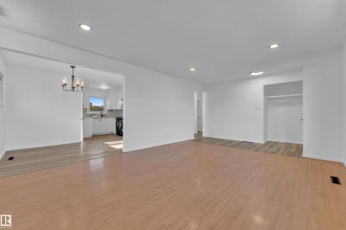 Open concept living space featuring light wood-finish flooring, recessed lighting, and a neutral color palette - 8104 135 Avenue, Edmonton, AB 