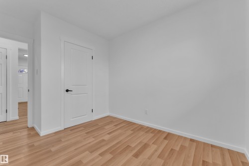 Interior room with light wood-finish flooring, white baseboards, and neutral wall paint - 8104 135 Avenue, Edmonton, AB 