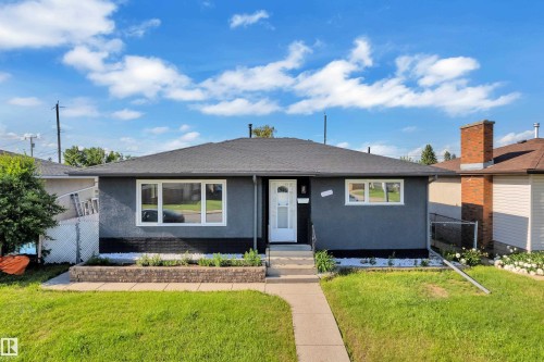Ranch-style residence featuring a dark gray stucco exterior with white trim - 8104 135 Avenue, Edmonton, AB 