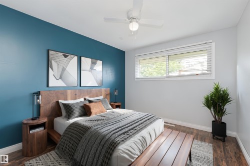 Bedroom featuring wood-finish flooring, a white ceiling fan, and a window with white blinds - 13411 140 Street, Edmonton, AB 