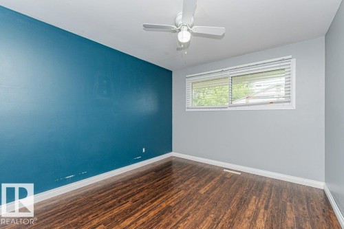 Room with wood-finish flooring, a white ceiling fan with light, and a window with white blinds - 13411 140 Street, Edmonton, AB 