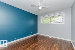 Room with wood-finish flooring, a white ceiling fan with light, and a window with white blinds - 