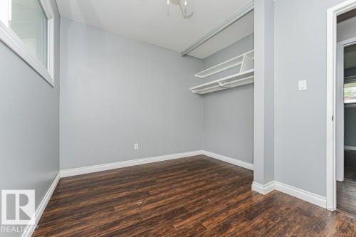 Room featuring wood-finish flooring, light gray wall paint, and white trim - 13411 140 Street, Edmonton, AB 