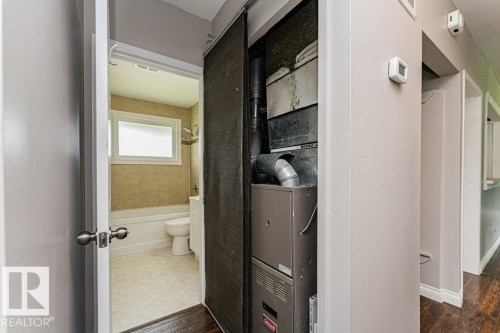 Bathroom featuring a white bathtub, toilet, and a window with privacy glass - 13411 140 Street, Edmonton, AB 