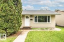 Exterior featuring stucco siding, a grey shingle roof, white trim windows, and a white paneled entry door with glass inserts - 13411 140 Street, Edmonton, AB 