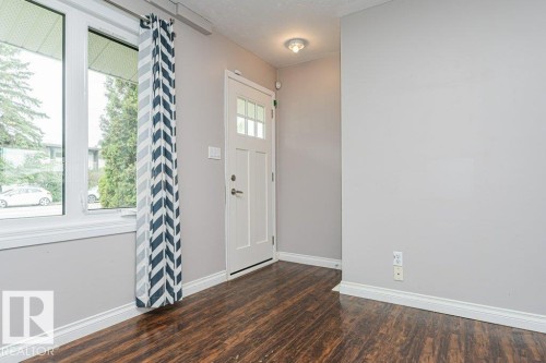 Entryway featuring wood-finish flooring, white baseboards, and light gray walls - 13411 140 Street, Edmonton, AB 