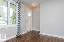 Entryway featuring wood-finish flooring, white baseboards, and light gray walls - 13411 140 Street, Edmonton, AB 