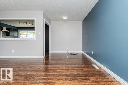 Wood-finish flooring throughout, featuring a pass-through window with white trim - 13411 140 Street, Edmonton, AB 