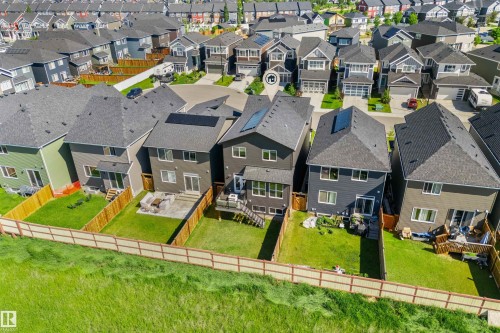 Modern residential architecture featuring a dark gray exterior, prominent solar panels, and a gabled roofline - 19 Sturtz Place, Leduc, AB 