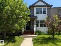 Contemporary exterior featuring gray horizontal siding and white shingle accents - 2143 32 Street, Edmonton, AB 
