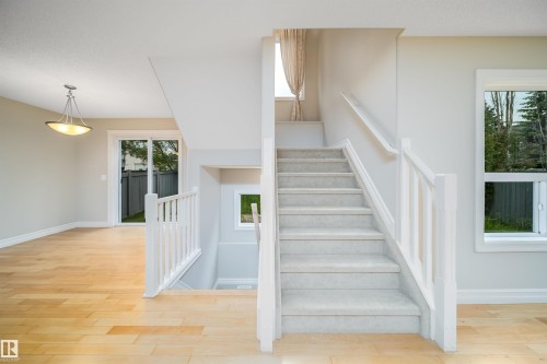 Carpeted staircase featuring white railings and risers - 11312 13 Ave Sw, Edmonton, AB 