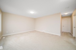 Spacious room featuring neutral carpeting, light-toned walls, and white trim - 